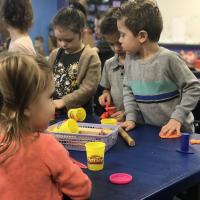 preschool student using play dough