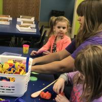 Miss Steph helps at the play dough table