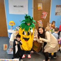 Miss Rhe posing with Spike and students